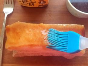 用叉子在五花肉皮上戳些小孔，用刷子刷上酱香鲜晾干