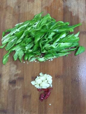 青椒去蒂去籽清洗干净后切成块儿，蒜瓣剁碎，干辣椒切成段儿备用！

