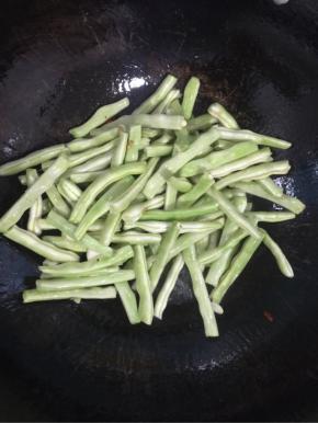 倒入沥干水分的四季豆翻炒均匀！

