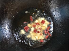 锅烧热倒入适量的油，放入蒜瓣，干辣椒爆香！

