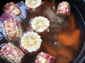 电压锅里放入清水，倒入排骨，玉米，胡萝卜，放入姜片，适量放一点醋，放醋可以使排骨的钙质更好的挥发，但是不要放多