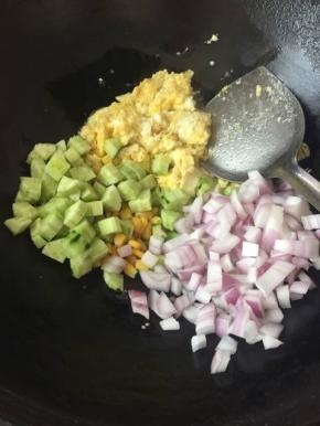 鸡蛋好了之后，把葱，黄瓜，洋葱，玉米粒一起倒进去炒匀