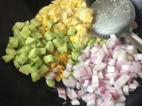鸡蛋好了之后，把葱，黄瓜，洋葱，玉米粒一起倒进去炒匀
