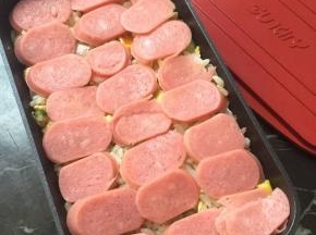 烤肠切片，模具里放入炒好的米饭铺上一层烤肠，再铺上一层芝士