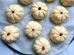 用牙签印出南瓜线条，中心放上一个枸杞，蒸盘上放一张油纸，放上南瓜饼，冷水上锅蒸10分钟即可