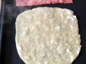 将饼皮和培根放在电饼档上煎至两面金黄，培根煎熟