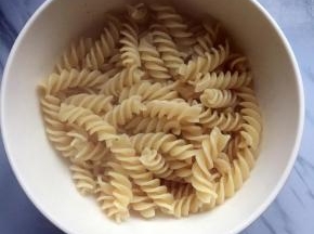 煮熟后捞出沥干水分，滴入几滴油防粘