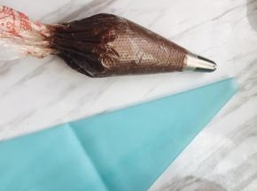 裱花嘴我用的是最普通的8齿花嘴和挤玫瑰花嘴，装入裱花袋里，把面糊装入裱花袋，将面糊用刮板推向裱花嘴，这里家里有硅胶裱花袋的，可再套一个在外面层，没有就有两个裱花袋，这样保险一点，以免挤破了，挤的手法要垂直于烤盘上，挤花时手接近裱花嘴的位置更好挤