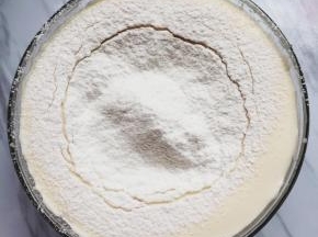 鸡蛋打发以后就可以预热烤箱了，把烤箱预热到上下火170度。筛入低筋面粉，用刮刀快速的翻拌