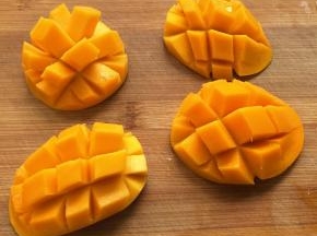 1.芒果沿着果核切开，用刀在果肉上划十字刀，再把果皮翻转