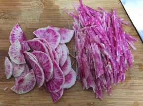 从萝卜中间对半切开，再切薄片切丝，可留几片做花瓣点缀，