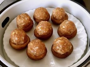 用勺子挖一勺肉圆放在香菇上面（如果香菇不稳，可以在香菇顶部削一层皮），放入盘子，上锅蒸15分钟