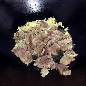 热锅冷油，放入蒜蓉和姜片爆香，倒入牛肉片