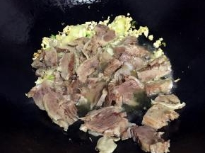热锅冷油，放入蒜蓉和姜片爆香，倒入牛肉片