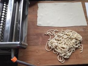 用面条机压出面条，没有可以用擀面棍擀成面皮再切丝