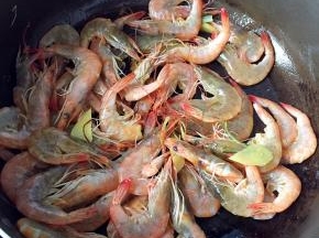 倒入虾炒至变色，倒入些许料酒去腥