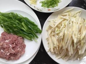 先把材料清洗干净，茭白去老根和外皮切丝，青椒切丝，葱切碎，蒜剁成蓉待用