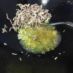 肉丝炒至变色后拨到一边，倒入葱白，蒜蓉炒出香味