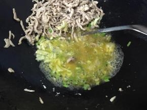 肉丝炒至变色后拨到一边，倒入葱白，蒜蓉炒出香味