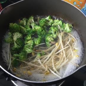 煎好香菇的锅直接加清水煮沸，倒入西兰花和豆芽，煮1分钟