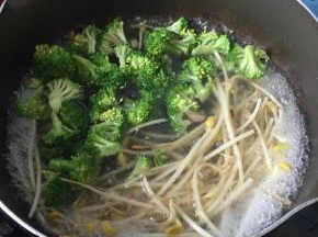 煎好香菇的锅直接加清水煮沸，倒入西兰花和豆芽，煮1分钟