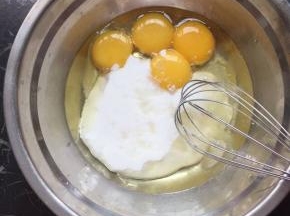 准备两个干净无水无油的盆把鸡蛋分离，倒入玉米油和酸奶翻拌均匀
