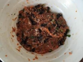 把肉糜和其它配菜放入碗内，加入料酒，生抽，盐，胡椒粉、鸡精拌匀