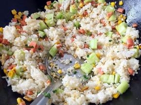 倒入剩米饭，用铲子压碎炒匀