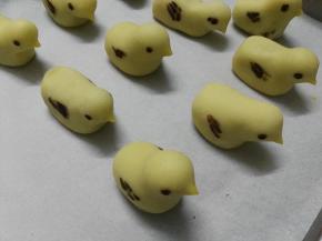 在每个小鸡嘴上用筷子抹上蛋黄液，放入烤盘里等待烘烤，注意在做小鸡的过程中加盖保鲜膜，防止小鸡表面干裂