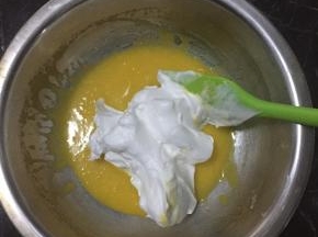 打发好的蛋白取一半和蛋黄用翻拌的手法混合均匀
