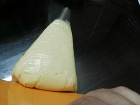 用刮板将面糊慢慢往裱花嘴方向推，直至面糊从裱花嘴出口微露