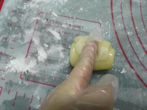 取一个油酥皮，手指按压中间。