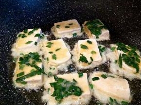 不粘锅倒油3勺，手放在上面，微微有点热了，就可以放豆腐煎，先不要去翻它，等定型以后翻面煎，