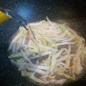  煎好鸡蛋，可以再加一点点油，直接炒白菜，翻炒片刻，加入开水，可以没过榨面就可以，