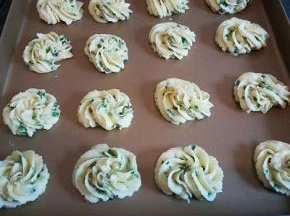 装入裱花袋，用的是8瓣花瓣的裱花嘴， 挤入不粘烤盘，