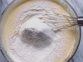 筛入低筋面粉，用刮刀从底部捞起的翻拌方式将蛋液和面粉混合好。翻拌过程速度要快，动作要轻。
