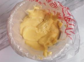 取一裱花袋，套在一个开口大的杯子上，倒入面糊，然后用剪刀在裱花袋口剪个圆口。