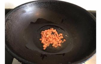 锅内倒入适量菜籽油，倒入火腿肠丁翻炒