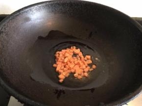 锅内倒入适量菜籽油，倒入火腿肠丁翻炒