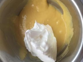 将1/3蛋白霜倒入蛋黄糊里混合