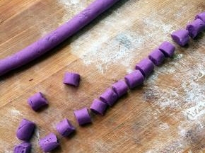 案板上撒少许面粉，然后将面团搓长条、切小块