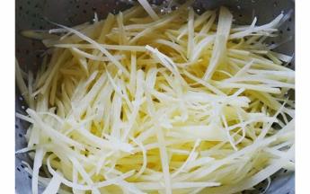 土豆切细丝，放入水中浸泡去除淀粉然后沥干水分