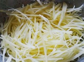 土豆切细丝，放入水中浸泡去除淀粉然后沥干水分