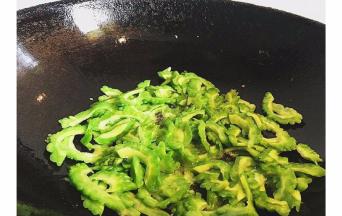 然后锅内再倒入少许油，倒入苦瓜翻炒
