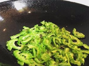 然后锅内再倒入少许油，倒入苦瓜翻炒