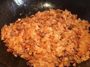 然后倒入糯米均匀地炒上色，加入一小勺猪油炒匀即可