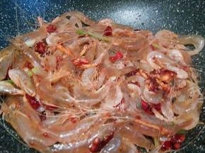 再放入江白虾翻炒变色，加料酒，生抽，盐，