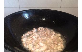 锅内倒入适量油，倒入肉丁翻炒
