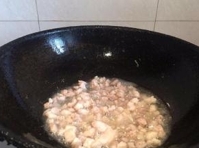 锅内倒入适量油，倒入肉丁翻炒