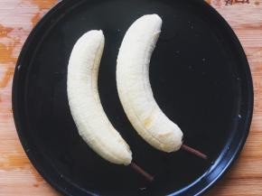将香蕉去皮，底部插上饼干棒